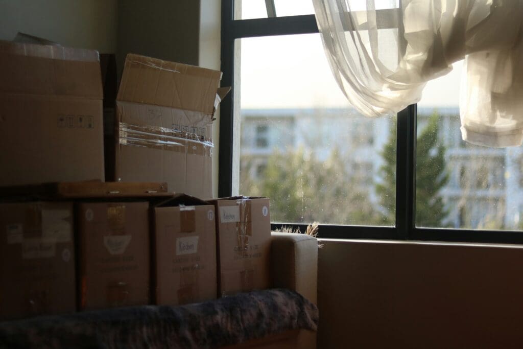 Moving boxes in a bright room, representing a new chapter and life change.